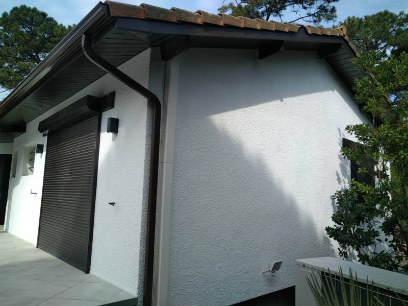 Pose des sous-faces en aluminium chêne foncé sur une maison traditionnelle dans le Nord des Landes à Biscarrosse